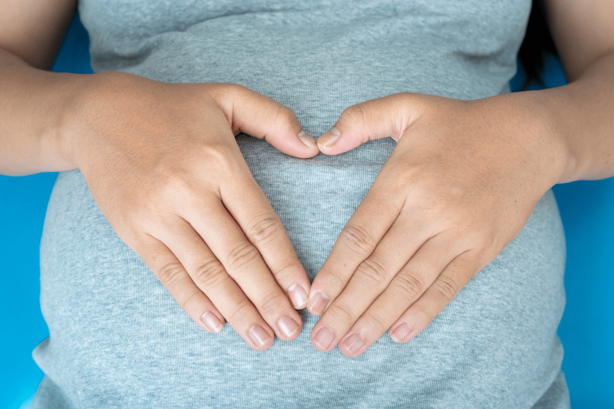 pregnant woman with hands in shape of heart over belly